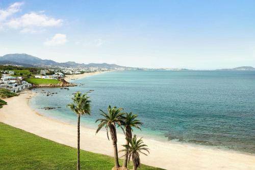 a view of a beach with palm trees at The St. Regis La Bahia Blanca Resort - Tamuda Bay in Fnidek