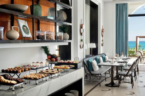 a buffet line with food on display in a restaurant at The St. Regis La Bahia Blanca Resort - Tamuda Bay in Fnidek