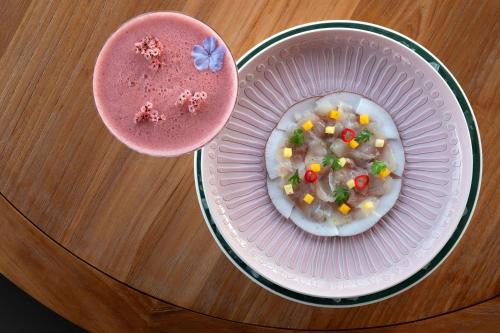 a plate of food in a bowl next to a drink at The St. Regis La Bahia Blanca Resort - Tamuda Bay in Fnidek