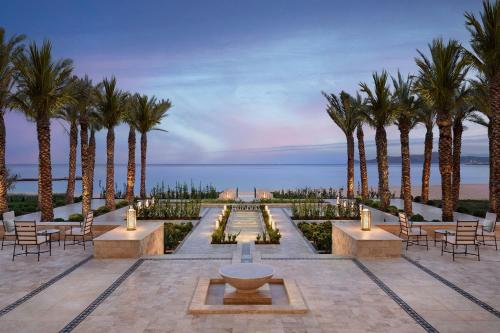a park with palm trees and a fountain at The St. Regis La Bahia Blanca Resort - Tamuda Bay in Fnidek