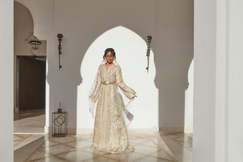 a woman in a white dress standing in a room at The St. Regis La Bahia Blanca Resort - Tamuda Bay in Fnidek
