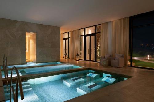 a large swimming pool in a room with at The St. Regis La Bahia Blanca Resort - Tamuda Bay in Fnidek