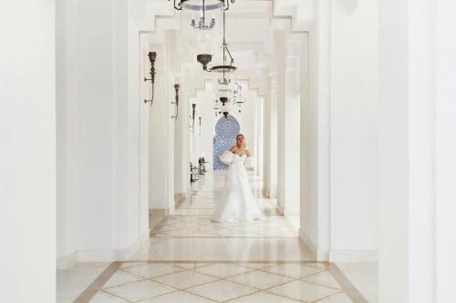 a bride in a wedding dress standing in a hallway at The St. Regis La Bahia Blanca Resort - Tamuda Bay in Fnidek