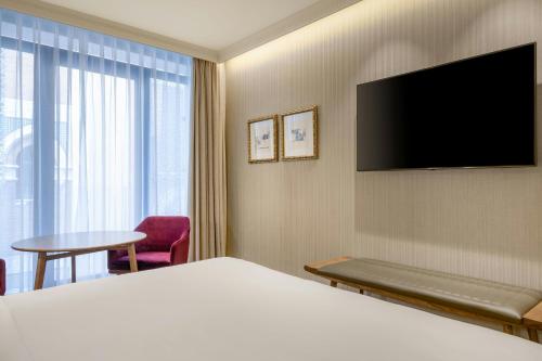 a hotel room with a bed and a flat screen tv at Querencia de Sevilla, Autograph Collection in Seville