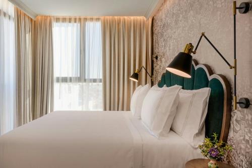 a bedroom with a large bed with white pillows at Querencia de Sevilla, Autograph Collection in Seville