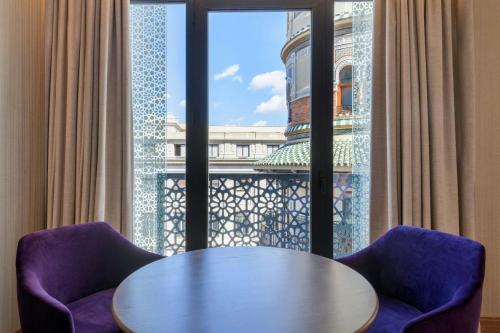 a table and two chairs in front of a window at Querencia de Sevilla, Autograph Collection in Seville