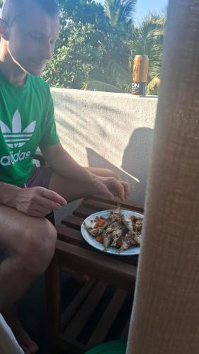 a person sitting on a table with a plate of food at RKO Villa27 - Unawatuna in Habaraduwa