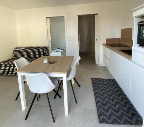 une cuisine avec une table et des chaises dans une pièce dans l'établissement La Maisonnette T2 charmant jardin parking La Cadière d'Azur 1 à 4 personnes, à La Cadière-dʼAzur