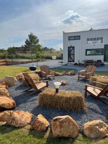 a patio with benches and rocks and a building at Tiny Escape Charlotte in Pak Chong