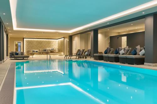 a large pool with blue water in a hotel lobby at Holzapfel in Bad Füssing