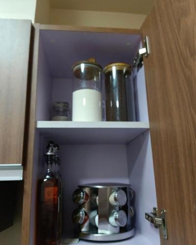 a cupboard with a shelf with a bottle and cups at Bayfront 1BR Condo in Pasay Manila with Wi-Fi, Netflix & Pool Access, Near NAIA Airport, Mall of Asia, OKADA, CCP & PICC in Manila