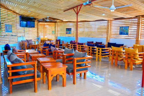 a dining room with wooden tables and chairs at MARKDON VILLAGE HOTEL Dodoma in Dodoma