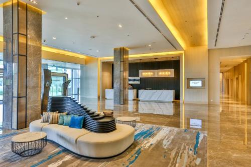 a lobby with a couch and some tables and chairs at Courtyard by Marriott Iloilo in Iloilo City