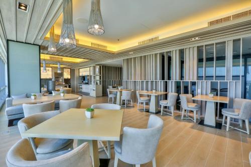 a restaurant with tables and chairs and a screen at Courtyard by Marriott Iloilo in Iloilo City