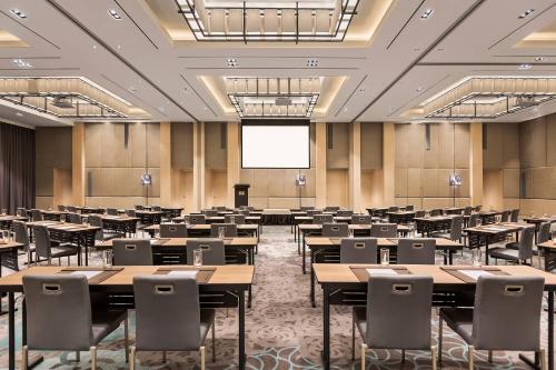 an empty room with tables and chairs and a projection screen at Courtyard by Marriott Iloilo in Iloilo City