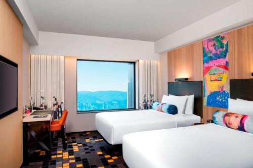 a hotel room with two beds and a window at Aloft Taipei Beitou in Taipei