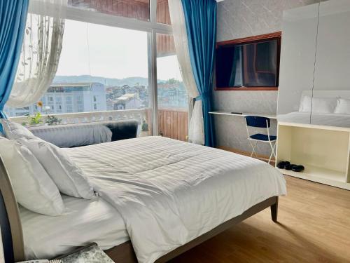 una camera da letto con un letto grande con una grande finestra di Villa - Hotel Nam Khang 2 Dalat a Da Lat