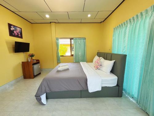 a bedroom with a large bed and a television at Thungwua laen resort in Chumphon