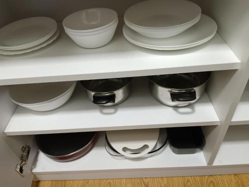 a shelf with plates and bowls on it at Sky room 12 in Mladenovac