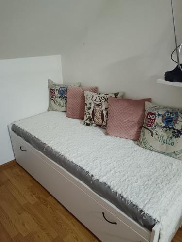 a bed with pillows on it in a room at Sky room 12 in Mladenovac