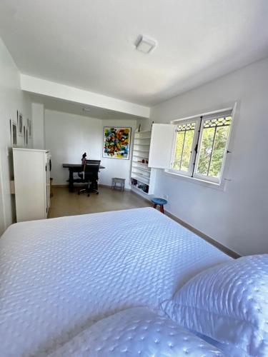 a bedroom with a bed and a desk in a room at Sunrise Paradise in Cayru