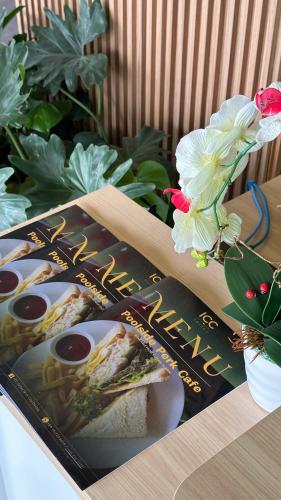 a book on sandwiches on a table with flowers at IPOH City Centre ICC Suites by HWC in Ipoh