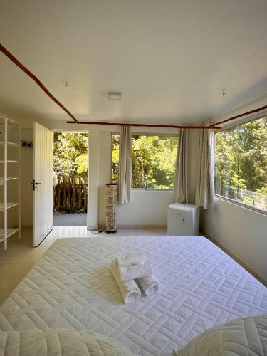 a bedroom with a large white bed with windows at Sunrise Paradise in Cayru