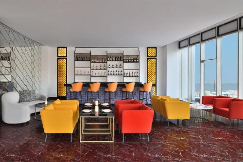 a dining room with colorful chairs and a table at Le Meridien Hyderabad in Hyderabad