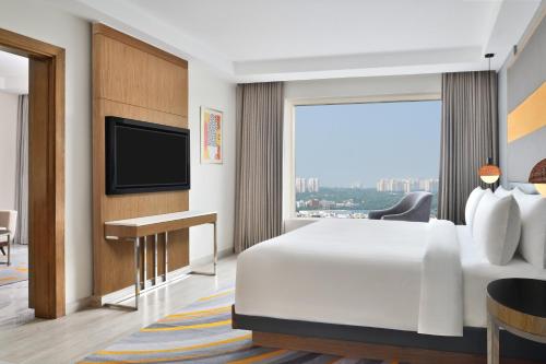 a hotel room with a bed and a flat screen tv at Le Meridien Hyderabad in Hyderabad