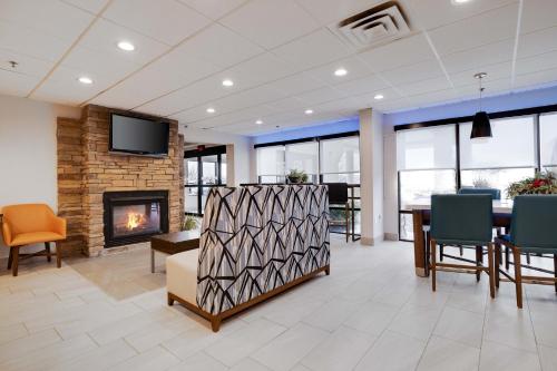 a lobby with a fireplace and a table and chairs at Holiday Inn Express Wilkes Barre East by IHG in Wilkes-Barre