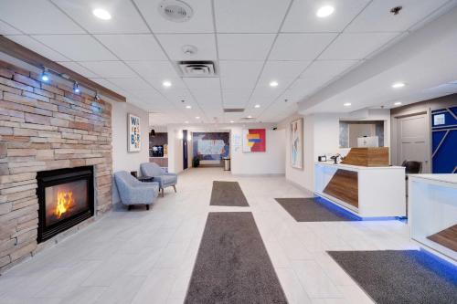 a living room with a fireplace and a kitchen at Holiday Inn Express Wilkes Barre East by IHG in Wilkes-Barre