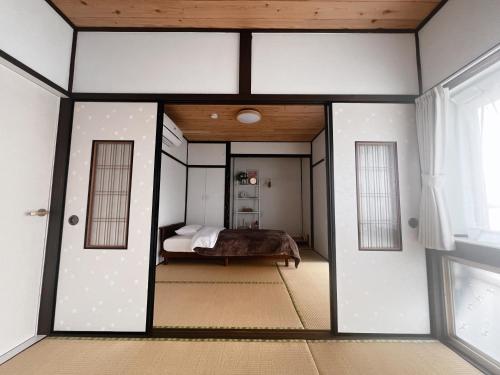 a bedroom with a bed in a room at 夕日と海の貸切宿 海しずく in Nobotate
