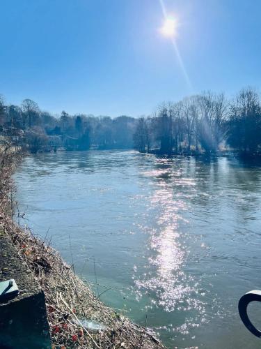 a river with the sun reflecting on the water at House close to nature in Esneux