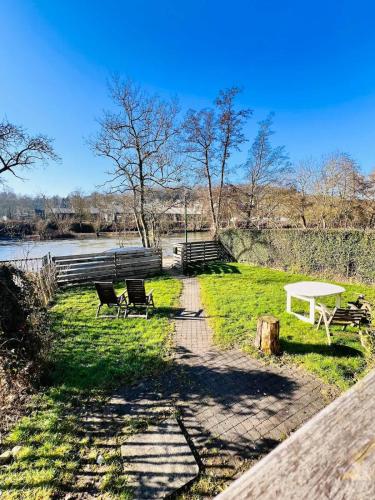 a park with a bench and a table and chairs at House close to nature in Esneux
