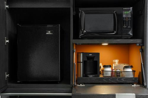 a small kitchen with a microwave and a refrigerator at Courtyard by Marriott Indianapolis Fishers in Fishers