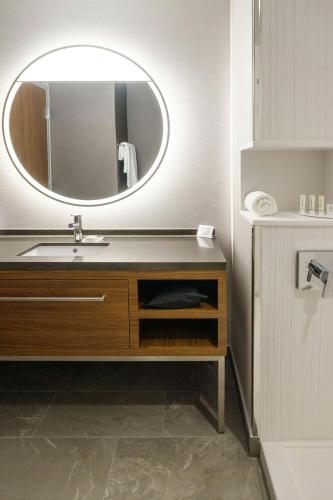 a bathroom with a sink and a mirror at Courtyard by Marriott Indianapolis Fishers in Fishers