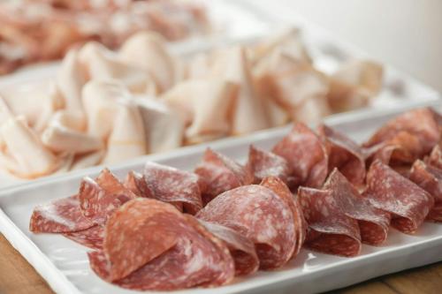 a white plate of meat on a table at AC Hotel by Marriott Milan Sesto in Sesto San Giovanni