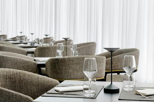 a row of tables and chairs with wine glasses on them at AC Hotel by Marriott Milan Sesto in Sesto San Giovanni