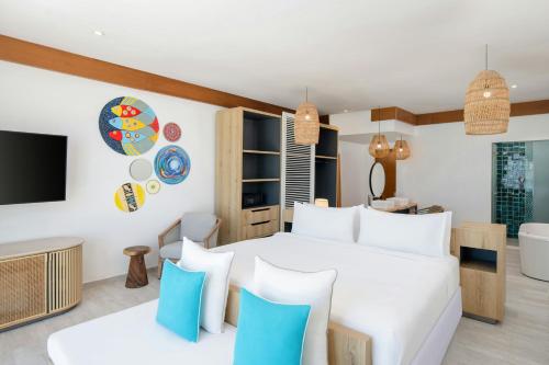 a bedroom with a white bed with blue pillows at Le Mersenne Zanzibar, Autograph Collection in Michamvi