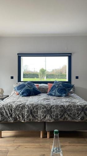une chambre avec un lit avec une grande fenêtre dans l'établissement La Parenthèse Normande, à Saint-Cyr-du-Ronceray