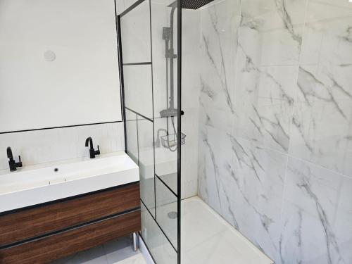 une salle de bain avec douche et lavabo dans l'établissement La Parenthèse Normande, à Saint-Cyr-du-Ronceray