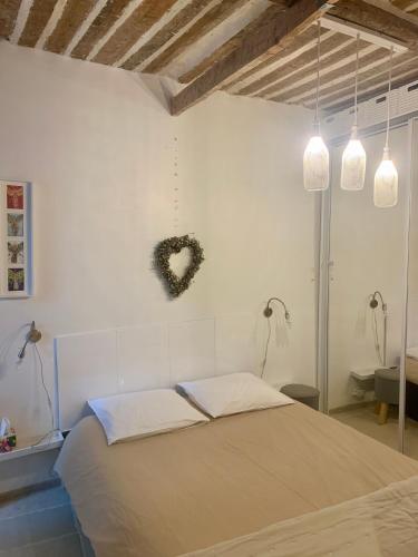 une chambre avec un lit avec un cœur sur le mur dans l'établissement Cannes Suquet appartement cosy, à Cannes