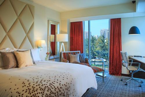 a hotel room with a bed and a desk and a window at Renaissance Santiago by Marriott in Santiago