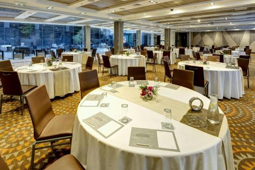 a banquet hall with white tables and chairs at Renaissance Santiago by Marriott in Santiago