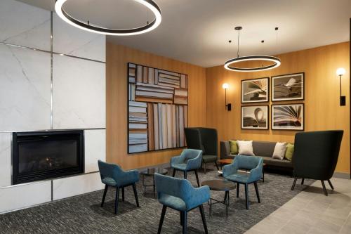 a waiting room with chairs and a fireplace at Courtyard by Marriott Montreal Airport in Dorval