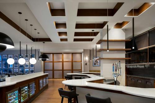 a large kitchen with a bar and chairs at Courtyard by Marriott Montreal Airport in Dorval