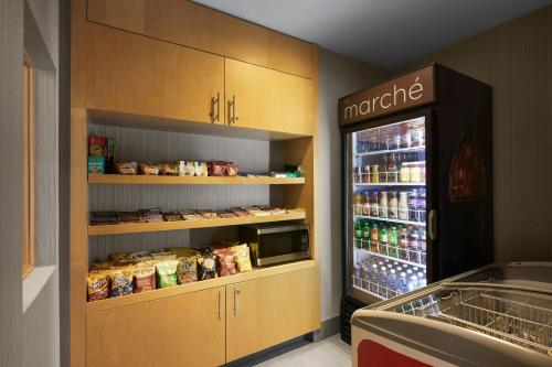 a store with an open refrigerator with food in it at Courtyard by Marriott Montreal Airport in Dorval