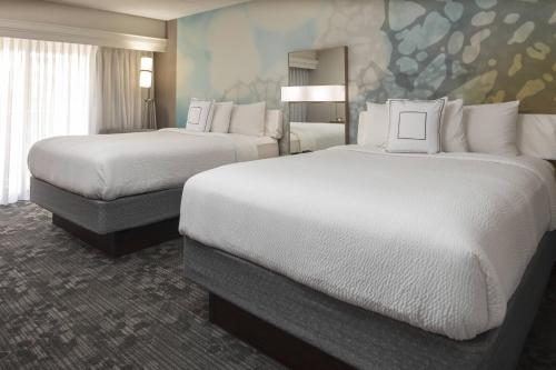 a hotel room with two beds and a mural at Courtyard Indianapolis Northwest in Indianapolis