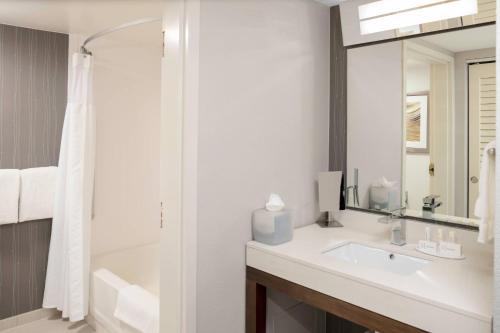 a bathroom with a sink and a mirror at Courtyard Indianapolis Northwest in Indianapolis