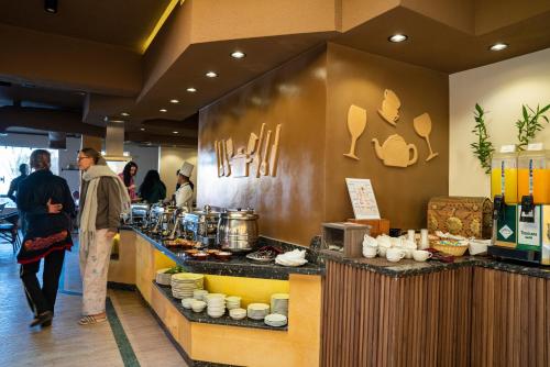 a restaurant with people standing at a counter at Al Dora Resort All Inclusive Hotel in Hurghada